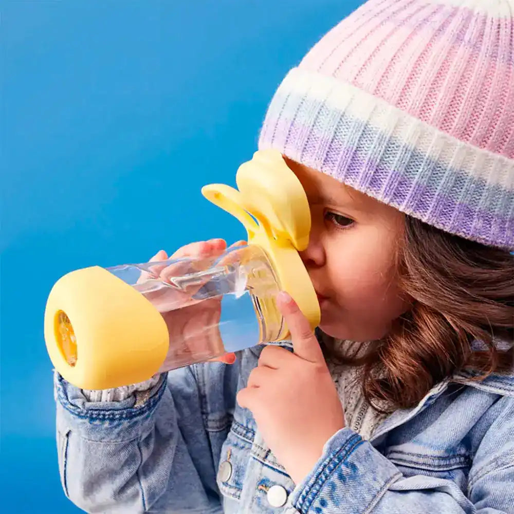 Niño bebiendo de una botella de agua con temática de plátano.